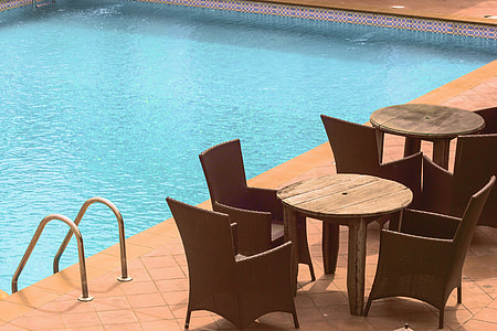closeup photo of table and chairs near pool thumbnail