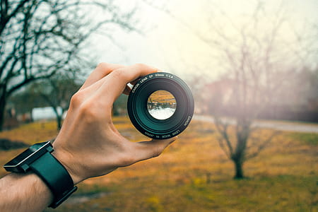 person holding camera lens thumbnail