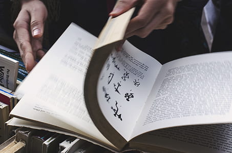 person opening white book pages thumbnail