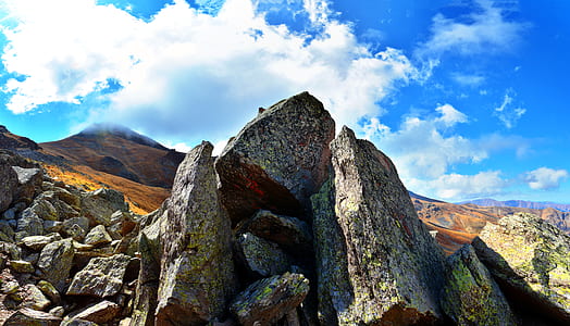 gray rock formation under cloudy sky thumbnail