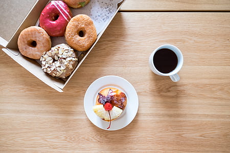 white ceramic cup filled with coffee near sweet dessert food on saucer thumbnail