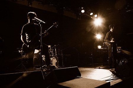 closeup photo of two men playing guitar on stage thumbnail
