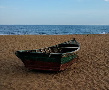 green and brown wooden jon boat by the beach thumbnail