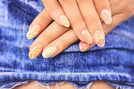 close up of human hand with lemon nail art on denim textile thumbnail
