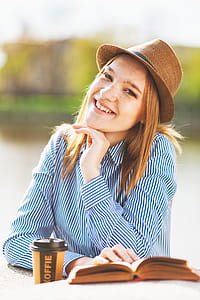Selected Focus Photo of Woman Holding Book on White Table thumbnail