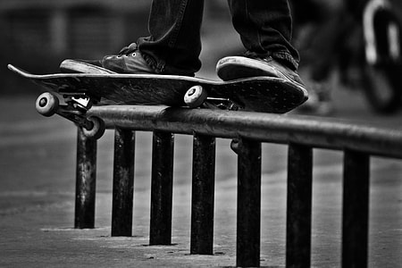 grayscale photography of person using skateboard on grindrail thumbnail