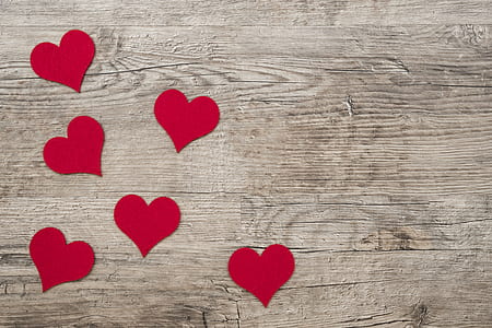 red heart cardboard cutouts on brown wooden surface thumbnail