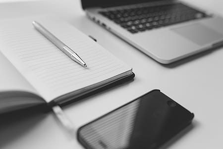 pen on top of open planner beside laptop and iPhone thumbnail