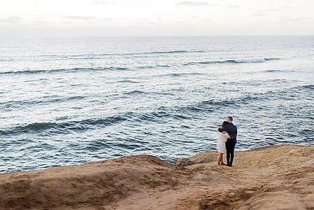 man and woman standing in front of body of water thumbnail