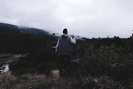 man holding tripod stand thumbnail