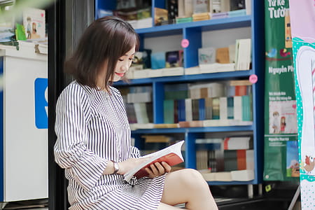 Woman Sitting While Reading A Book thumbnail