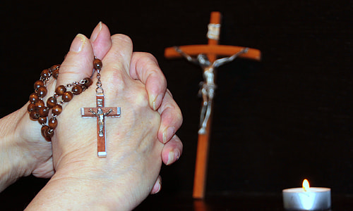 person holding brown prayer beads thumbnail