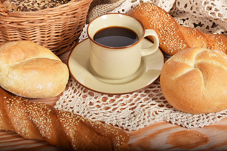 black coffee on white ceramic mug beside pastry breads thumbnail