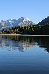 grey mountain near body of waters and trees during daytime thumbnail