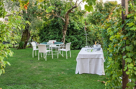 white and green patio set near table with white tablecloth near trees and green grass field at daytime thumbnail