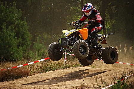 man riding ATV passing on hump photo thumbnail