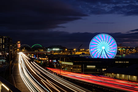 time lapse photo of street near ferriswheel at nighttime thumbnail