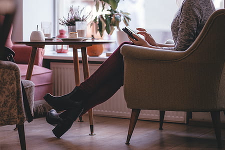 photo of woman sitting on sofa chair using smartphone thumbnail