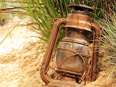 brown gas lantern on sand during daytime thumbnail