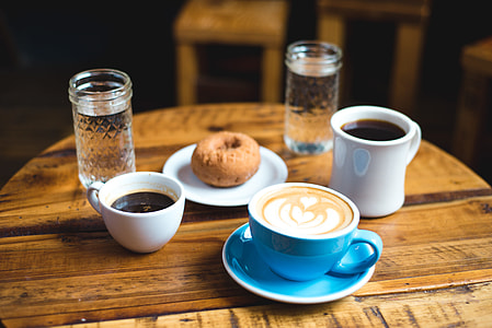 blue ceramic cup filled with cappuccino on brown wooden table thumbnail