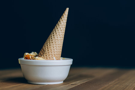 brown ice cream cone dipped on white ceramic bowl thumbnail
