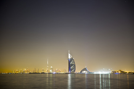 blue and white lighted building near body of water thumbnail