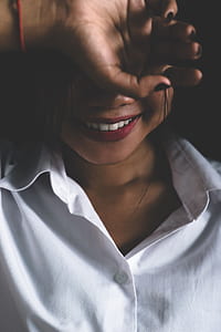 woman shows her teeth with lipstick in dark room thumbnail