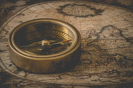 photo of gold-colored compass on brown map thumbnail
