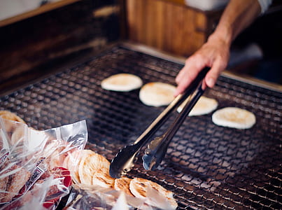 person holding thong while flipping roti bread during daytime thumbnail