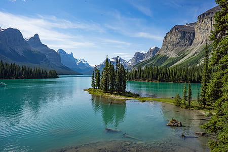 body of water surrounded by trees and mountains thumbnail