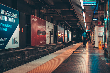 man wearing backpack walking near signs thumbnail