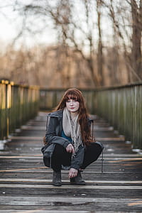 selective focus photo of woman ducking on suspension bridge thumbnail