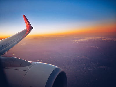 white and red Lufthansa airplane with the view of left wing during golden hour thumbnail