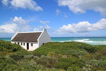 white concrete house under white clouds and blue sky thumbnail