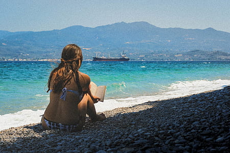 woman in bikini reading book on seashore thumbnail