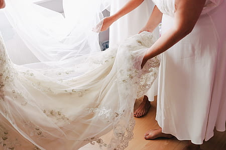 woman holding white lace wedding gown thumbnail