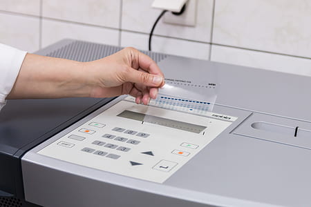 person holding paper beside machine thumbnail