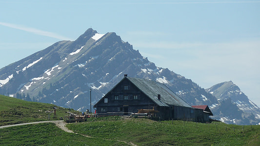 brown wooden house near mountain thumbnail