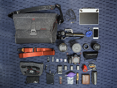 black DSLR camera kit with accessories  and bag on blue textile thumbnail