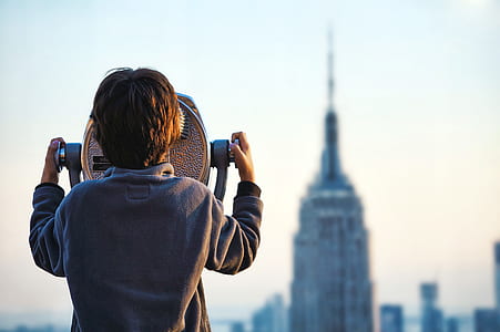 person using coin operated scope looking at Empire State building thumbnail
