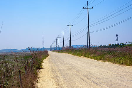 road in the middle of grass land during daytime thumbnail