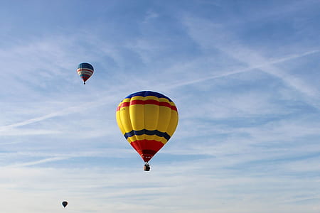 three assorted-color hot air balloons on mid air taken at daytime thumbnail