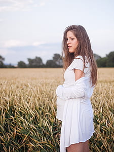 woman standing on grass during daytime thumbnail