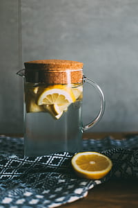 clear glass pitcher with lemons on top of black and white textile thumbnail