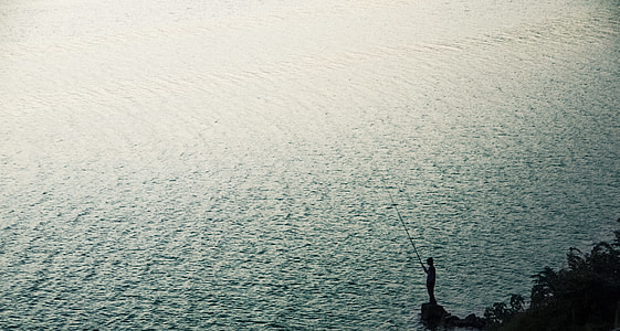 silhouette of person holding fishing rod thumbnail