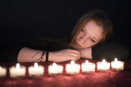 woman staring at tealight candles thumbnail