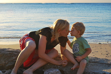 woman kissing toddler on seashore thumbnail