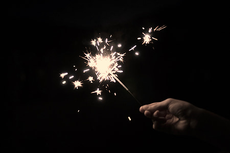 person holding sparkler on dark room thumbnail