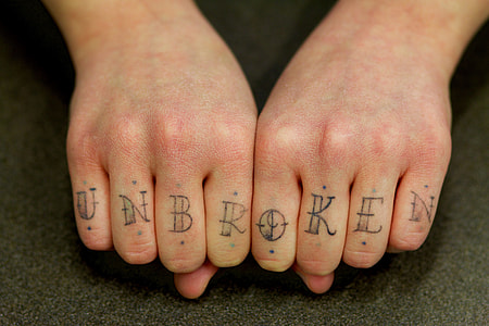 person showing unbroken tattoo on hand thumbnail