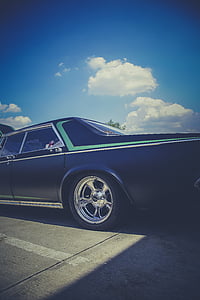 classic black sedan under blue sky thumbnail